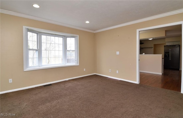 empty room with visible vents, baseboards, ornamental molding, dark colored carpet, and recessed lighting