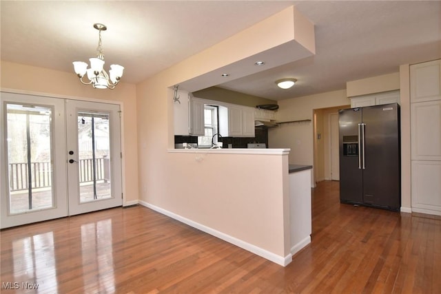 kitchen featuring french doors, wood finished floors, refrigerator with ice dispenser, and white cabinets