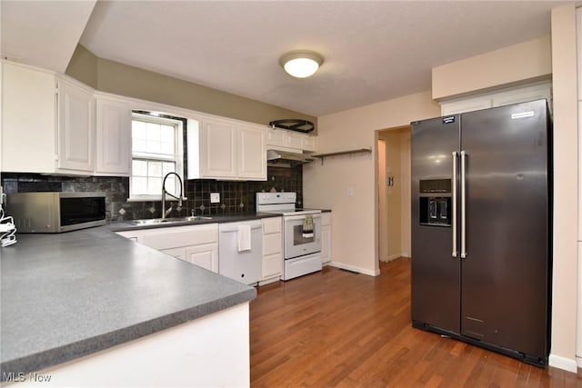 kitchen with white appliances, white cabinets, dark wood-type flooring, a sink, and backsplash