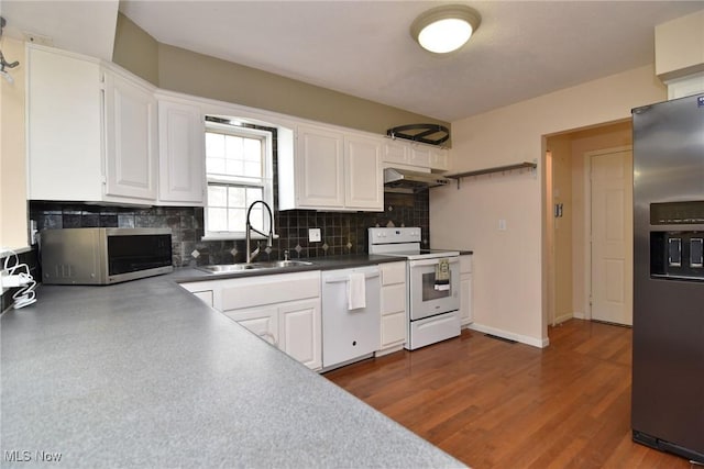 kitchen with tasteful backsplash, white cabinets, stainless steel appliances, under cabinet range hood, and a sink