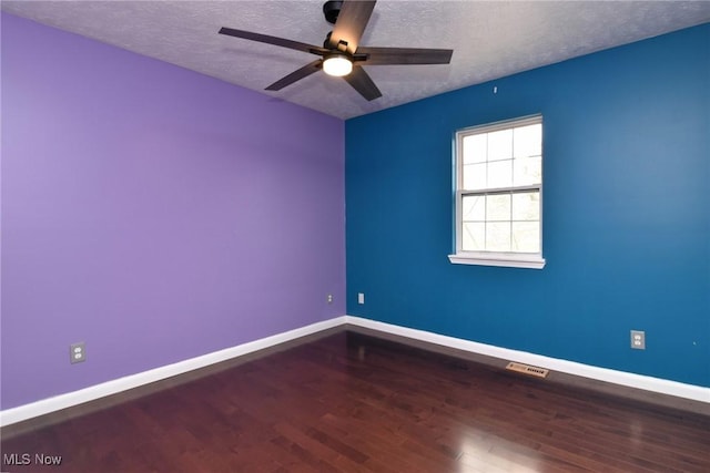 spare room with a textured ceiling, visible vents, and baseboards