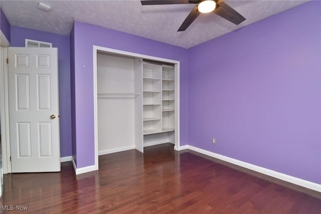 unfurnished bedroom with baseboards, ceiling fan, wood finished floors, a textured ceiling, and a closet