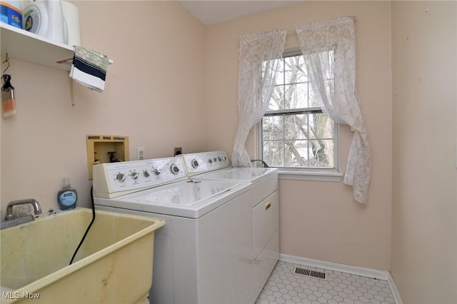 laundry area with a wealth of natural light, independent washer and dryer, laundry area, and a sink