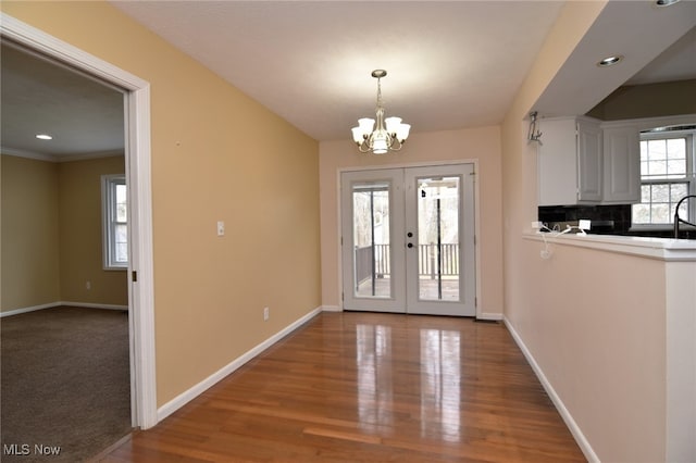 doorway to outside with french doors, recessed lighting, wood finished floors, a chandelier, and baseboards