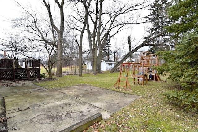 view of yard featuring a deck, a patio, and a playground