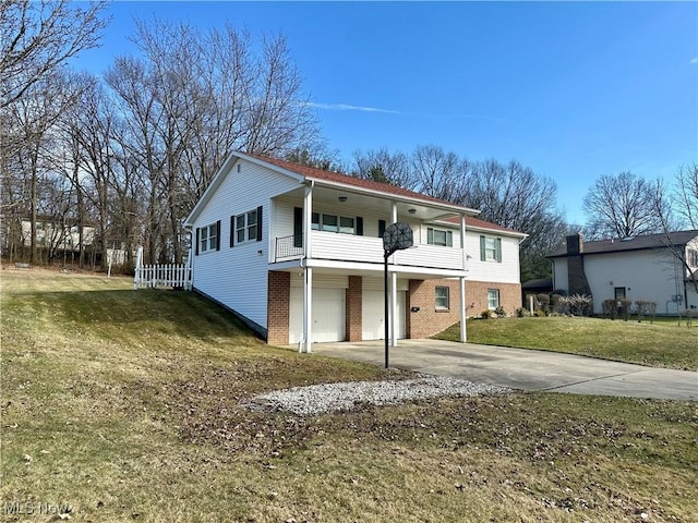 view of front of property featuring concrete driveway, a balcony, an attached garage, a front yard, and brick siding