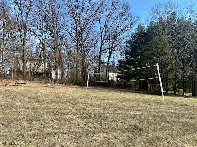 view of community with a lawn and volleyball court