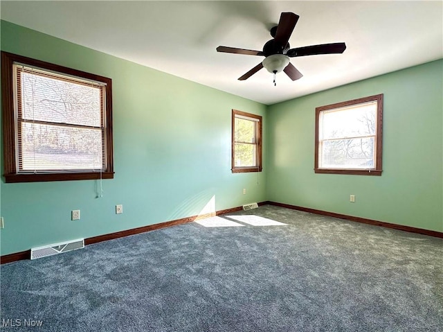 empty room featuring carpet, visible vents, and baseboards