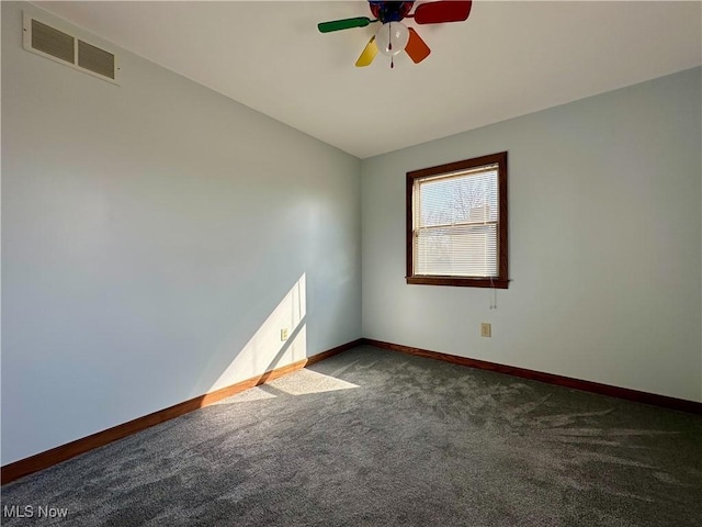 carpeted empty room featuring baseboards, visible vents, vaulted ceiling, and a ceiling fan