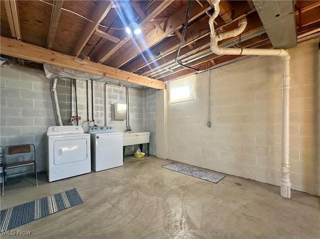 below grade area featuring separate washer and dryer and a sink