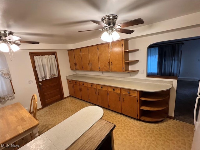 kitchen featuring brown cabinetry, light countertops, light floors, and open shelves