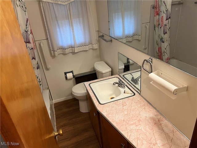 full bathroom featuring toilet, shower / bathtub combination with curtain, wood finished floors, and vanity