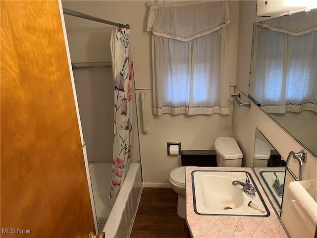 full bath with toilet, shower / tub combo, wood finished floors, a sink, and baseboards