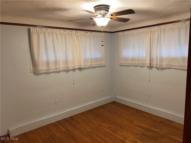 unfurnished room with hardwood / wood-style floors, a ceiling fan, and baseboards