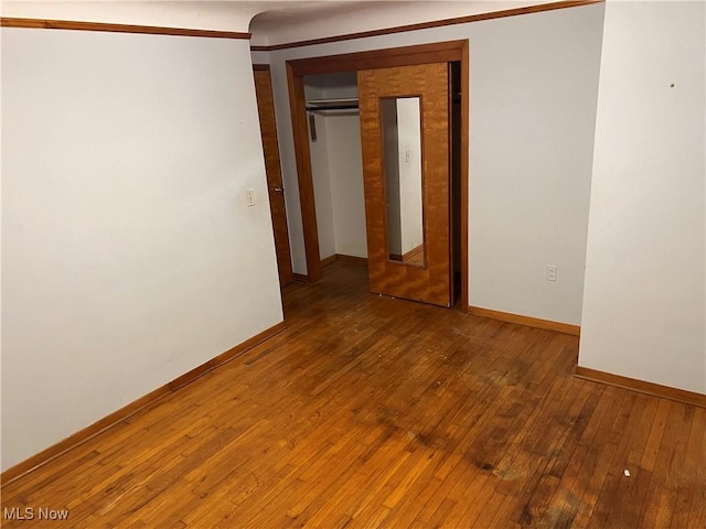 unfurnished room with wood-type flooring and baseboards