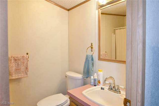 bathroom with crown molding, a textured ceiling, toilet, and vanity