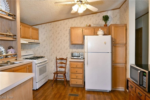 kitchen with dark wood-style floors, a textured ceiling, white appliances, under cabinet range hood, and wallpapered walls