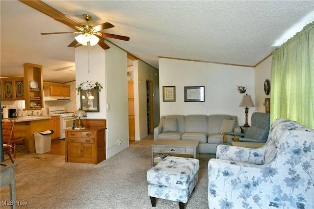 living area with a ceiling fan, vaulted ceiling, a textured ceiling, and light colored carpet