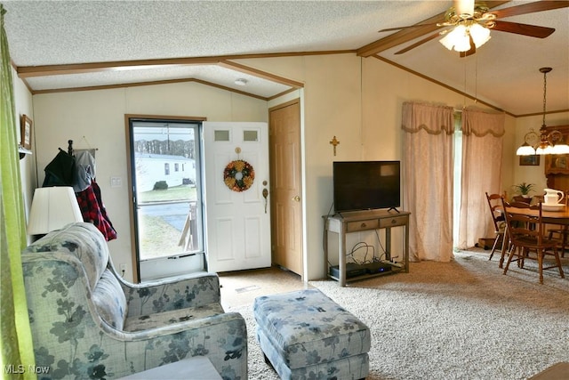 living room with ornamental molding, carpet flooring, vaulted ceiling, a textured ceiling, and ceiling fan with notable chandelier