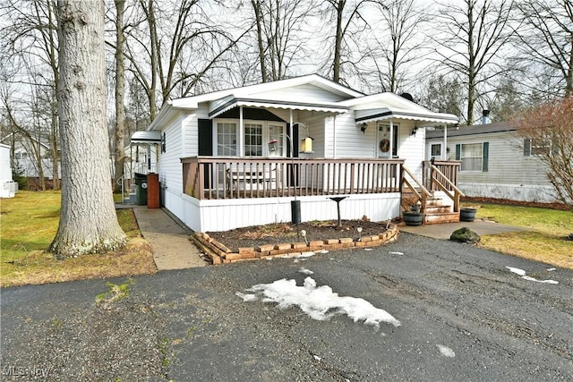 manufactured / mobile home featuring driveway and a porch