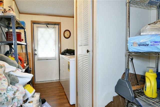 washroom featuring a textured ceiling, laundry area, ornamental molding, and wood finished floors