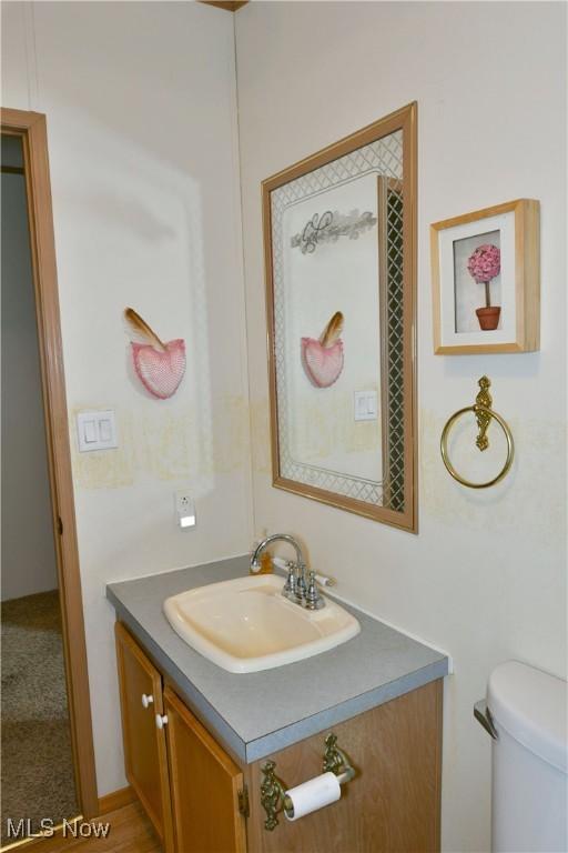 half bathroom featuring toilet and vanity