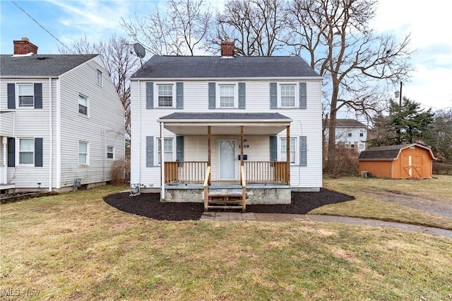 view of front of house featuring a chimney, covered porch, an outdoor structure, a shed, and a front lawn