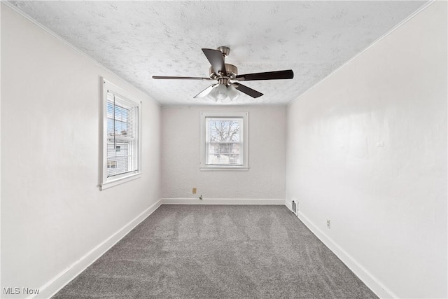 carpeted spare room featuring a textured ceiling, a ceiling fan, and baseboards