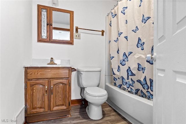 bathroom featuring toilet, shower / tub combo with curtain, wood finished floors, and vanity