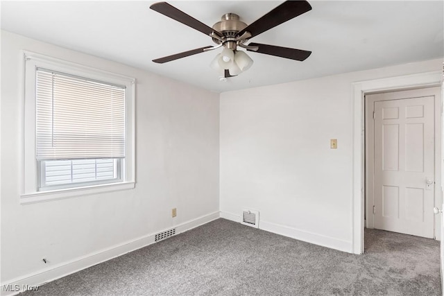 empty room with baseboards, visible vents, and carpet flooring