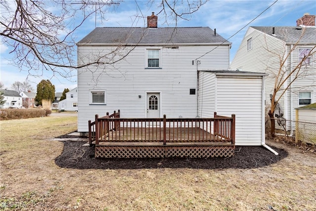 back of house with a chimney, fence, and a deck