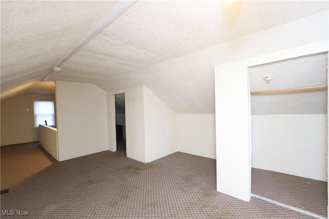 bonus room with carpet floors, vaulted ceiling, and a textured ceiling