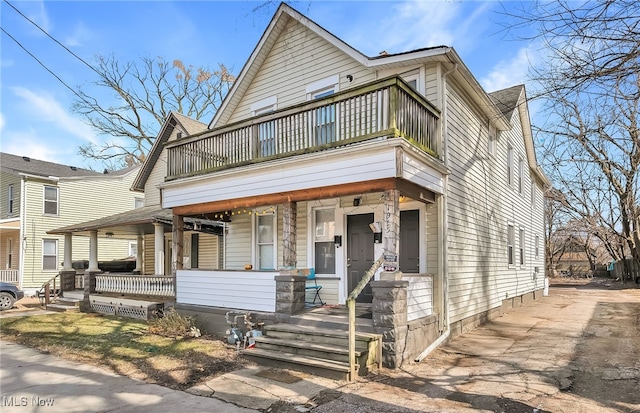 view of property featuring covered porch and a balcony