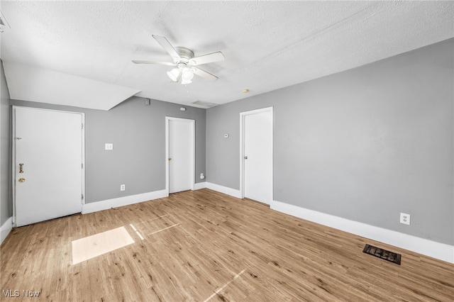 bonus room featuring a textured ceiling, wood finished floors, a ceiling fan, and baseboards