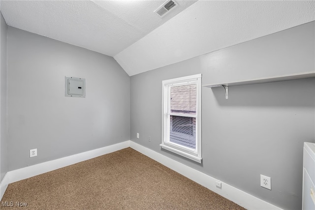 interior space with visible vents, baseboards, vaulted ceiling, a textured ceiling, and carpet flooring