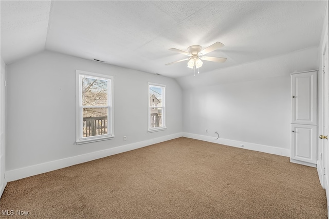 bonus room featuring visible vents, vaulted ceiling, a textured ceiling, and baseboards