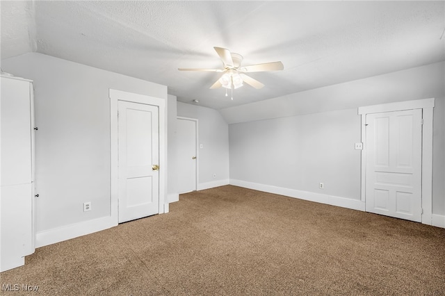 additional living space featuring baseboards, a ceiling fan, lofted ceiling, a textured ceiling, and carpet floors