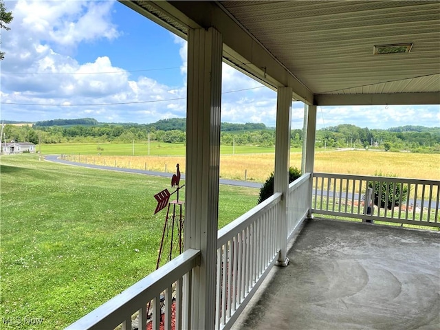 exterior space featuring a yard, a porch, and a rural view