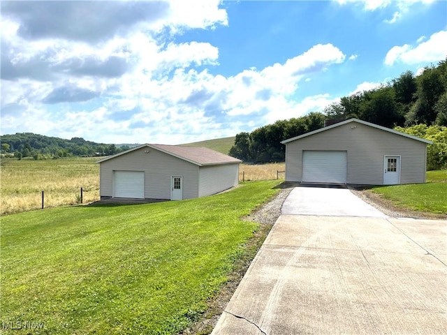 exterior space with a yard, an outdoor structure, and a detached garage