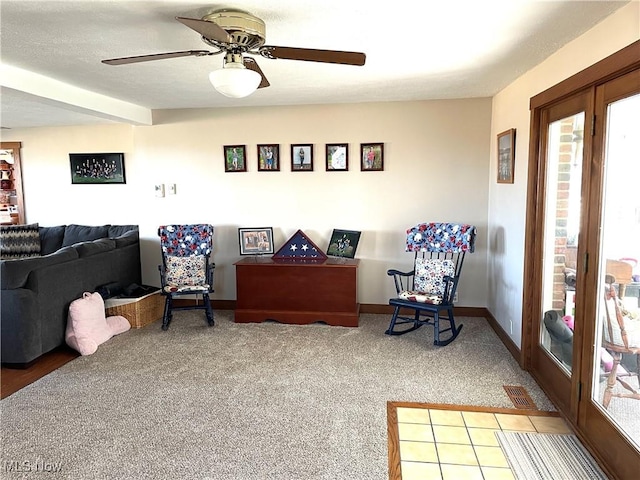 living area with a ceiling fan, carpet, visible vents, and baseboards