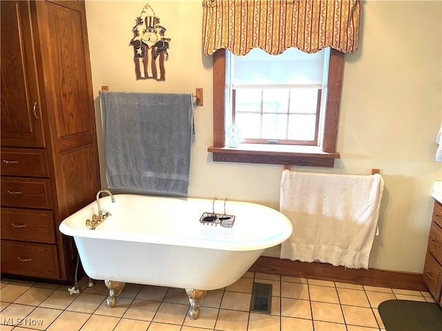 bathroom with a soaking tub, vanity, visible vents, and tile patterned floors