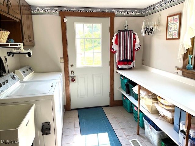 washroom featuring cabinet space, visible vents, washing machine and clothes dryer, and light tile patterned flooring