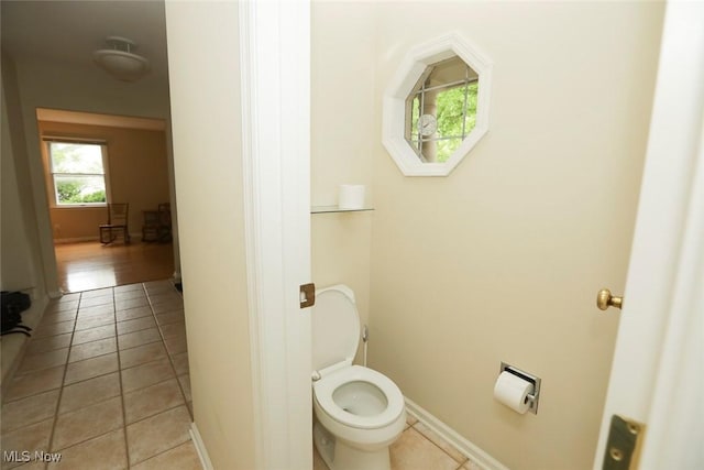 bathroom featuring toilet, baseboards, and tile patterned floors