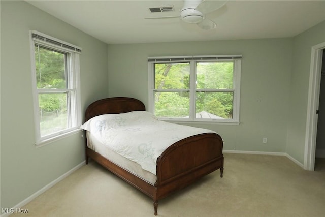 bedroom featuring visible vents, light carpet, baseboards, and multiple windows