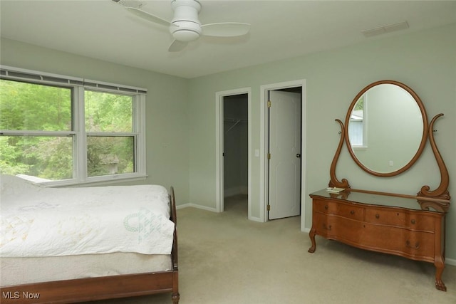 bedroom with ceiling fan, a spacious closet, baseboards, and light colored carpet