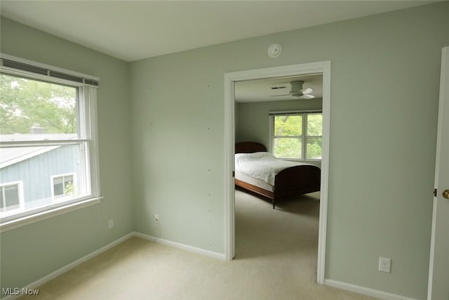 unfurnished bedroom with light carpet and baseboards