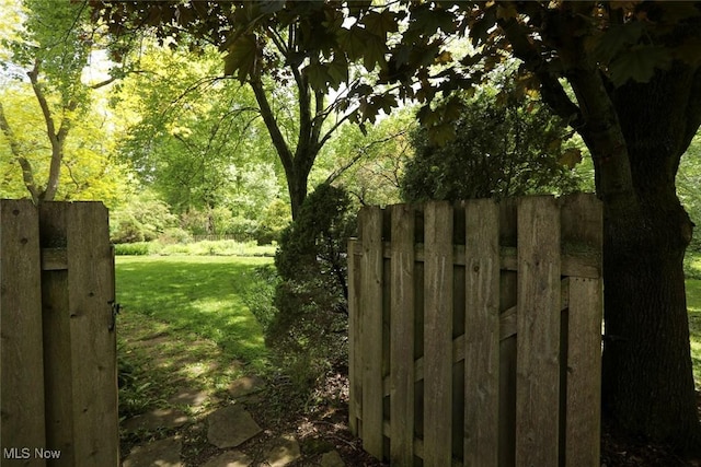 view of gate featuring a yard and fence