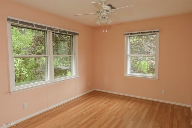 unfurnished room with ceiling fan, light wood-type flooring, and baseboards