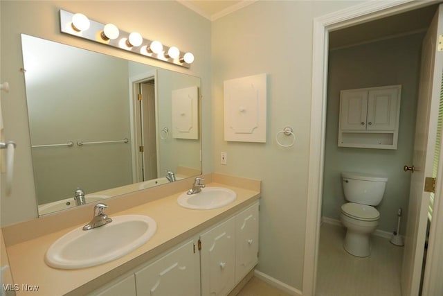 full bath with double vanity, baseboards, toilet, and a sink