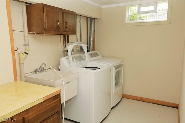 washroom with washer and dryer, cabinet space, and baseboards